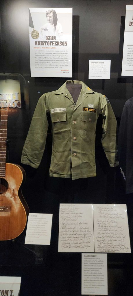 Country Music Hall of Fame and Museum exhibit displaying singer/songwriter Kris Kristofferson’s Army uniform shirt and hand-written manuscript for the song ‘Me and Bobby McGee.’
