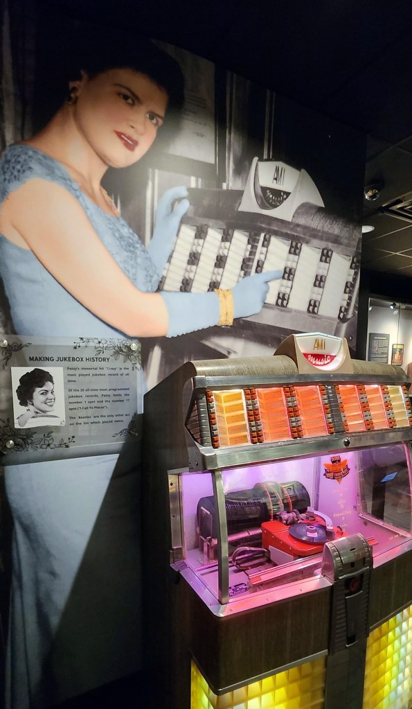 Exhibit in the Patsy Cline Museum depicting Patsy Cline standing next to a jukebox with a sign stating that her single hit ‘Crazy’ is the most played jukebox record of all time.